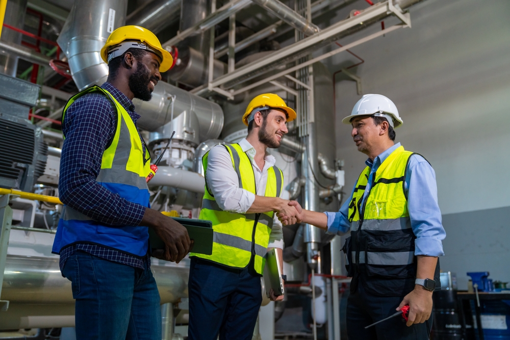 Three men with hard hats and safety vests